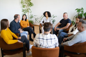 adults in support group sitting in circle and speaking