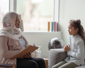 child and therapist talking during therapy session